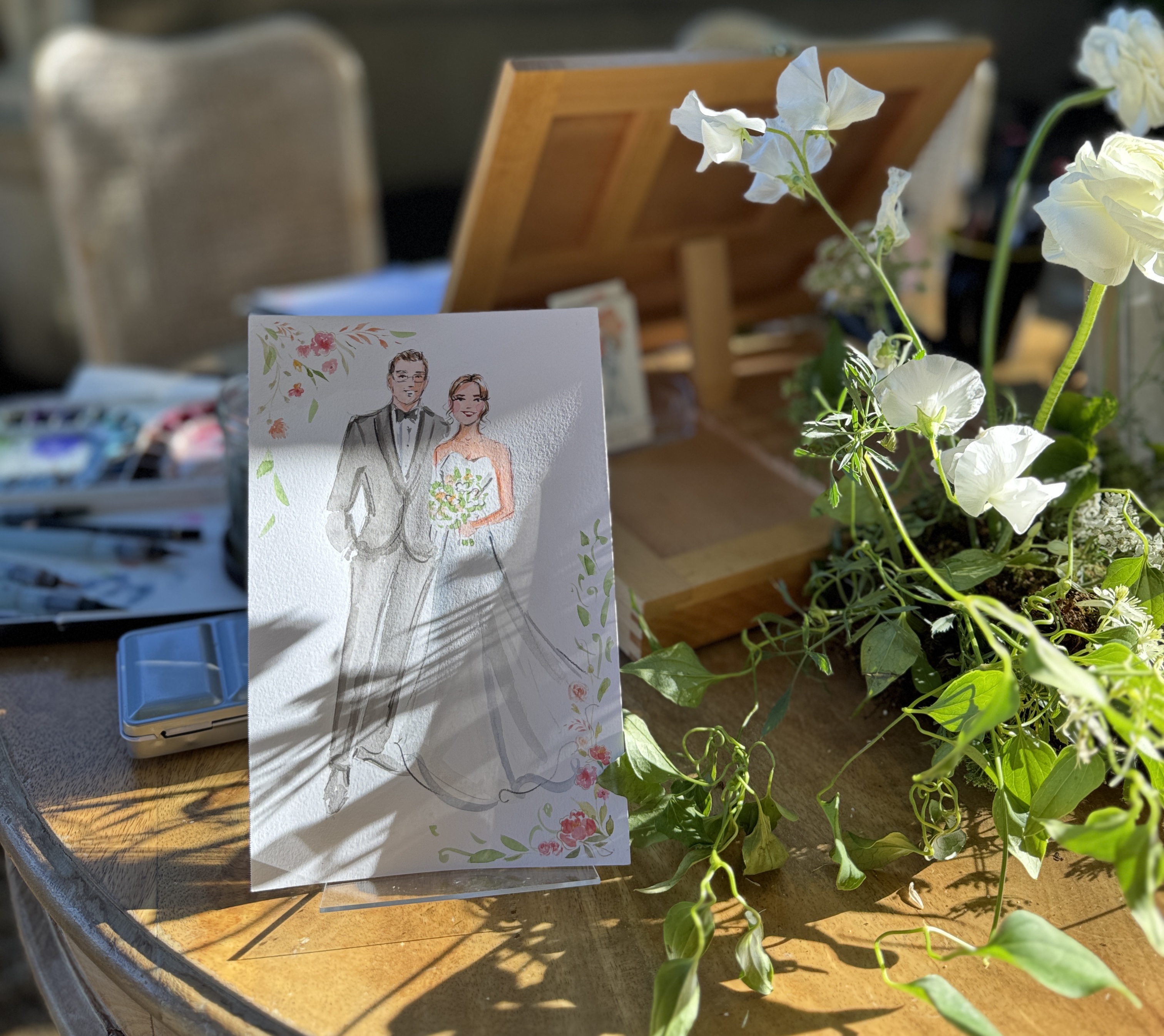 Guests receiving watercolor portraits from a live wedding painter for guests